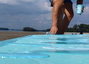 pouring blue background with hand on sand