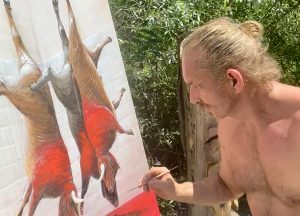 Artist painting the "Death in the Afternoon" artwork, using disturbing red colors to depict blood and the bullfighting theme.